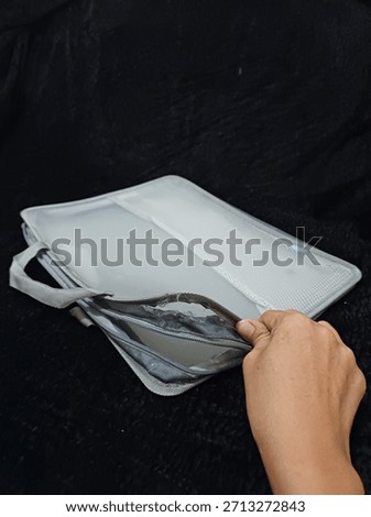 two plastic folders that cannot be used because the zipper is damaged and torn in several places