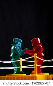 Two Plastic Robot Figures, Fighting With A Black Background