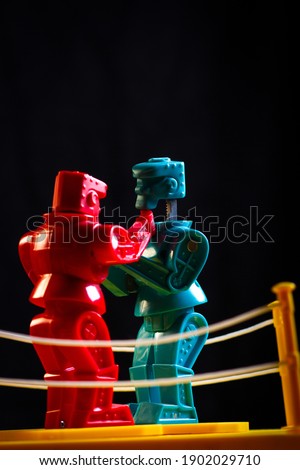 Two plastic robot figures, fighting with a black background