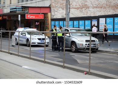 Two Police Officers Talking To A Driver Sitting In A Car In Melbourne Australia March,10 2019