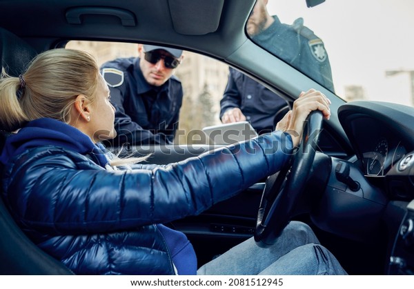 Two police\
officers talking with female\
driver