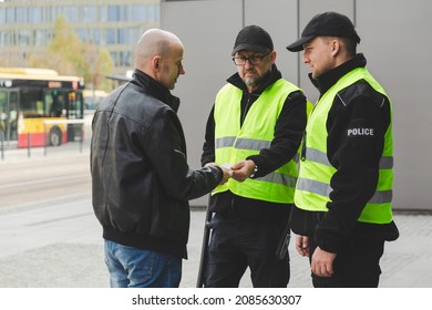 Two Police Officers Talking To Man On The Street