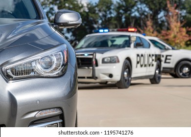 Two Police Vehicles Stop A Sedan On A Routine Traffic Stop