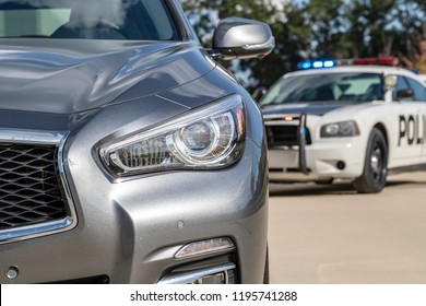 Two police vehicles stop a sedan on a routine traffic stop