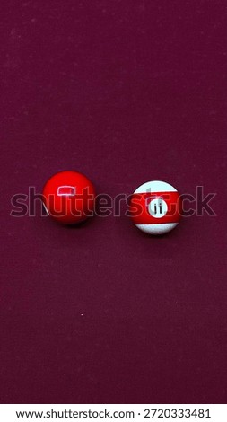 Two pool game balls placed on a billiard table, highlighting their glossy surface and bold colors. The simple composition represents focus, strategy, and the essence of cue sports. This image captures indoor recreation and leisure activity, making it ideal for concepts related to billiards, games, competition, and entertainment spaces.