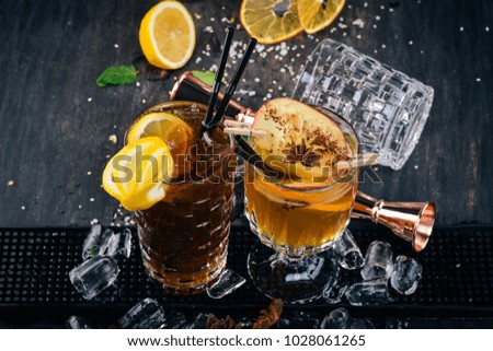 Two popular cocktails with ice. Long island On a black wooden background.