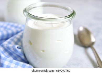 Two Portions Of Fresh Natural  Homemade Organic Yogurt In A Glass Jar On A Light Slate Background.