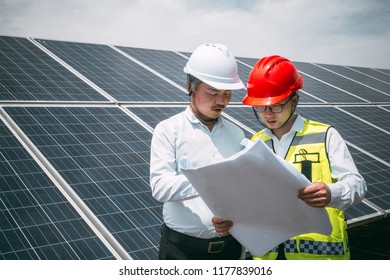 Two position engineers view drawings   repair equipment at solar energy base 