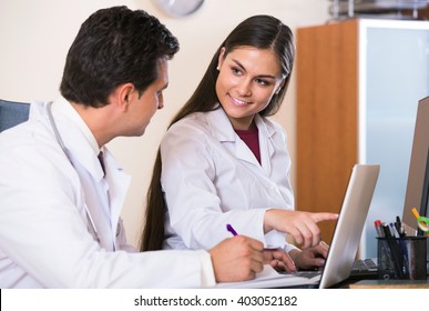 Two Positive Professional Doctors Brainstorming And Sharing Information In Clinic