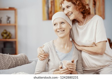 Two positive woman sitting together at home enjoining their time after radiation therapy - Shutterstock ID 1242880231