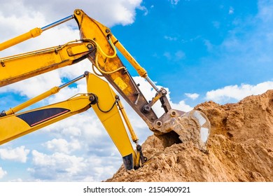 Two powerful excavators work at the same time on a construction site, sunny blue sky in the background. Construction equipment for earthworks