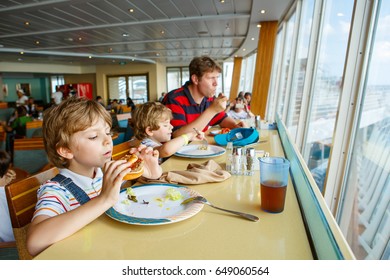 Two Preschool Kids And Father Boys Eating Pasta Hamburger Sitting In Cafe On Cruise Ship. Happy Children, Twins And Dad Eating Healthy Organic And Vegan Food In Restaurant. Childhood, Health Concept