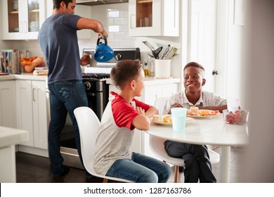 Two Pre-teen Male Friends Sit Talking In Kitchen At One BoyÃ•s House, Dad In The Background