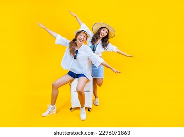 Two Pretty asian women passenger in trendy fashion is exciting to board while carrying her luggage bag in happiness for friendly trip and summer travel vacation isolated on yellow background - Powered by Shutterstock