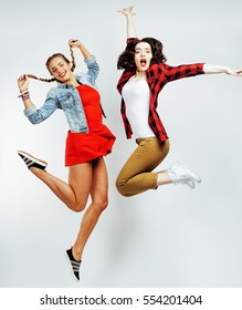 Two Pretty Brunette And Blonde Teenage Girl Friends Jumping Happy Smiling On White Background, Lifestyle People Concept