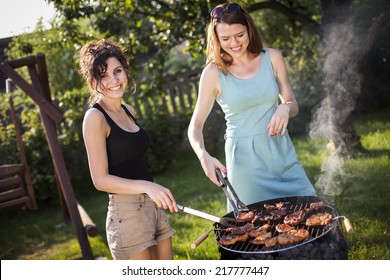 Two pretty girls making food on grill