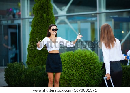 Two pretty women meet near the airport