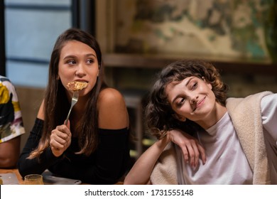 Two Pretty Young Girls Sitting At The Dinner Table