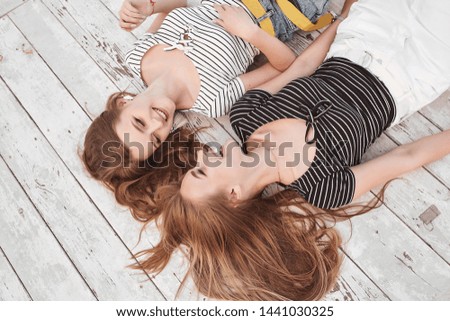 Similar – Two women with sunglasses smiling lying in blanket