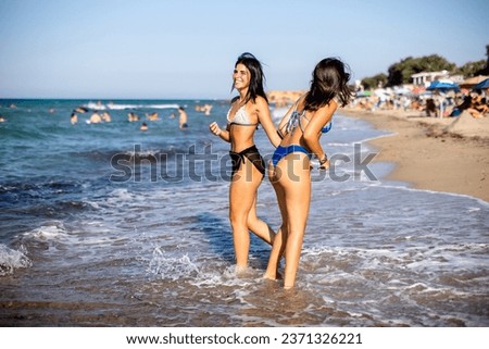 Similar – Image, Stock Photo Two women holding surfboard and looking at camera