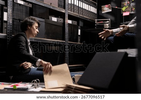 Two private detectives analyzing case files and archived information, tracing and connecting evidence between suspects and organized crime in a secret mission. Clandestine operation.