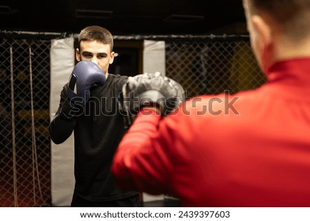 Two professional boxer boxing in dark gym. Boxer training concept. Copy space