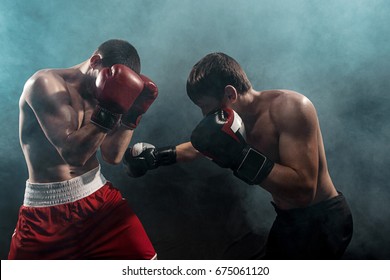 Two professional boxer boxing on black smoky background,