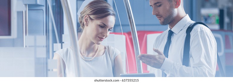 Two professional businesspeople talking during their journey by train