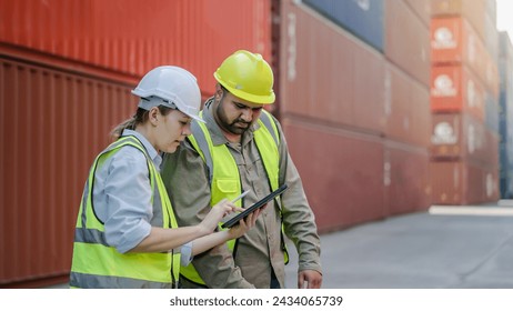 Two professional dock worker or engineering people discussing inventory lists with their supervisor while record data online with digital connection tablet at Container cargo, Import and Export - Powered by Shutterstock