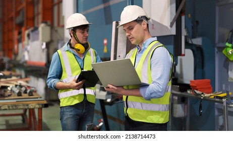 Two professional industrial engineer specialist with safety vast uniform and helmet holding laptop checking security of electrical control panel in private sector of industry safety security concept   - Powered by Shutterstock