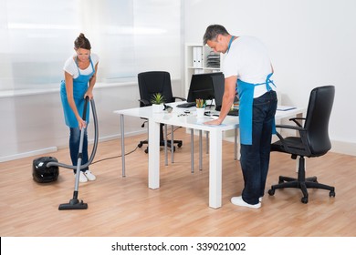 Two Professional Janitors Are Cleaning The Modern Office