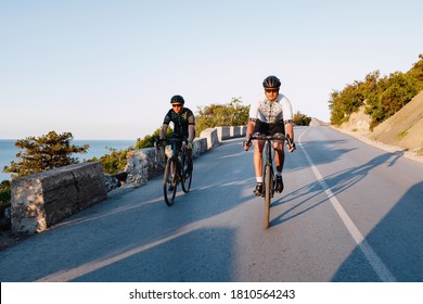 Two professional male cyclists riding their racing bicycles in the morning together