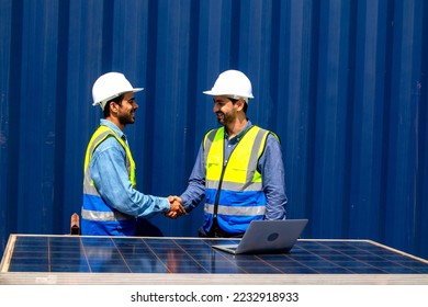 Two professional male engineers in helmets and uniforms shaking hands after signing a contract. Handshake as a symbol of greeting, congratulation, approval and farewell. - Shutterstock ID 2232918933
