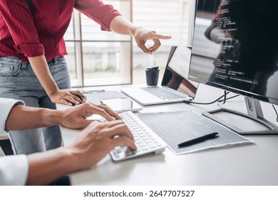 Two professional programmer cooperating and working on web site project in a software developing on desktop computer at company, codes and typing data code, Programming with HTML, PHP and javascript.