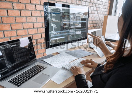 Two professional programmer cooperating and working on web site project in a software developing on desktop computer at company, codes and typing data code, Programming with HTML, PHP and javascript.