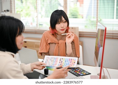 Two professional and talented Asian female graphic designers working on their new design project in the studio together. - Powered by Shutterstock