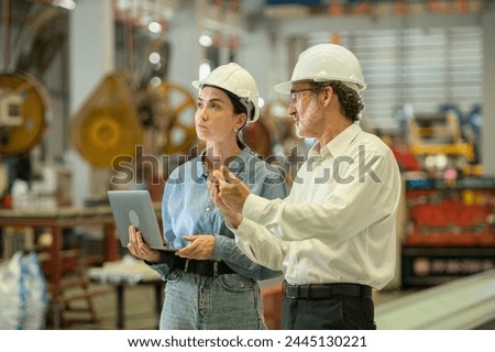 Two professional technician engineer worker use clipboard checking operating equipment machine monitors and check Production process machinery. Two engineer confederate control factory machine