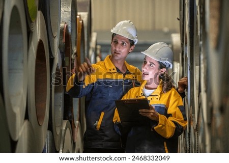 Two professional technician engineer worker use clipboard checking operating equipment machine monitors and check Production process machinery. Two engineer confederate control factory machine