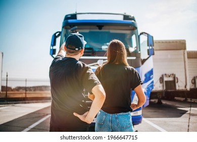 Two Professional Truck Drivers Stand In Front Of The Big Truck. They Talk And Perform A Technical Inspection Of The Vehicle Before Next Drive. Professional Transportation Concept.