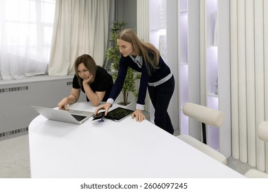 Two professionals collaborating on a project at a modern office workspace during the day