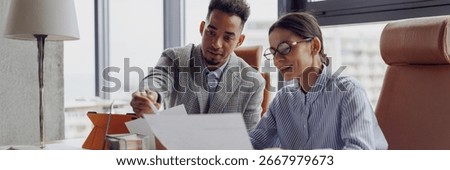 Two professionals discuss essential documents in a modern office to enhance collaboration and productivity