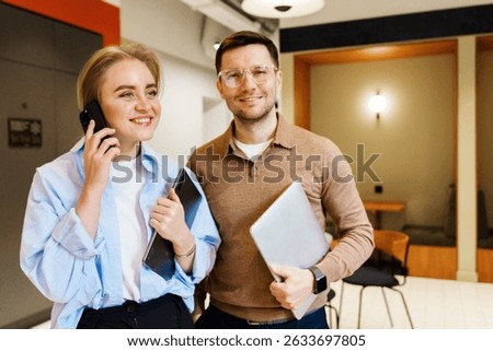 Two professionals engaging in conversation and collaboration in a modern workspace during daylight hours