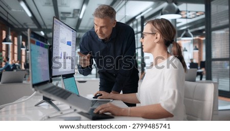 Two Professionals Examining Digital Risk Dashboard While Discussing Audit Results.