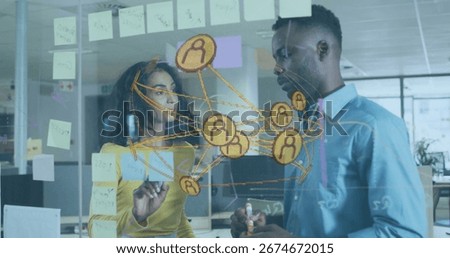 Two professionals sketching network map on glass board in open-plan office, colored markers. Collaboration, brainstorming, innovation, connectivity, teamwork, modernoffice, digitalnetwork