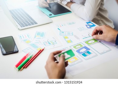 Two programmer discussing new project for developing technologies application designe of mobile phone. First process for sketch planning application.