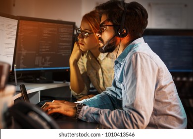 Two programmers working on new project.They working late at night at the office.