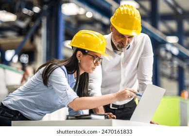 Two project managers standing in modern industrial factory. Manufacturing facility with robotics, robotic arms and automation. Storing products and materials in warehouse. - Powered by Shutterstock