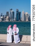 Two Qatari man standing at the Doha corniche, Qatar.