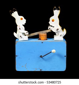 Two rabbits working with a saw, a wooden toy, music player, on isolated black background