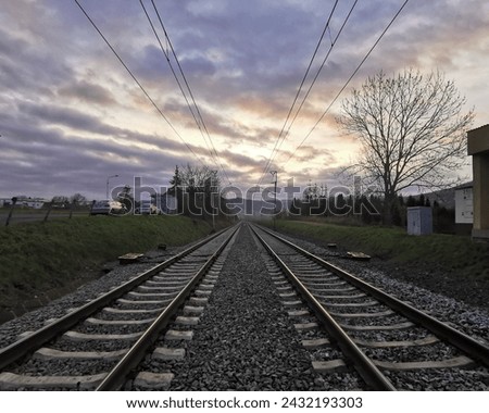Two railways on a cloudy day with partial sunlight in the background in uptown with bare tree in city winter. Two railways in empty late autumn countryside.